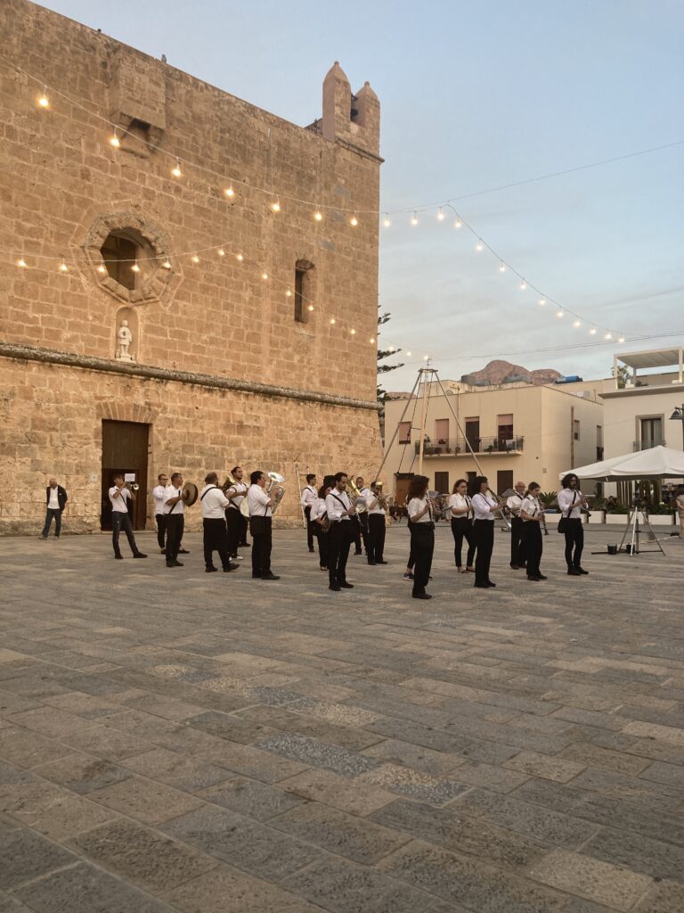 Musikkapelle vor der Pfarrkirche von San Vito Lo Capo während einer traditionellen Feier auf dem Kirchplatz in den Abendstunden.